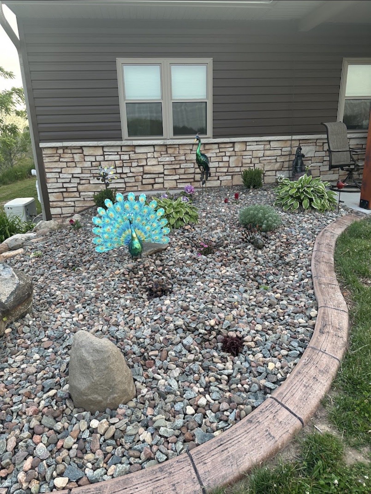 Rock garden landscaping with stone edging and plantings by Logan's Lawn Care